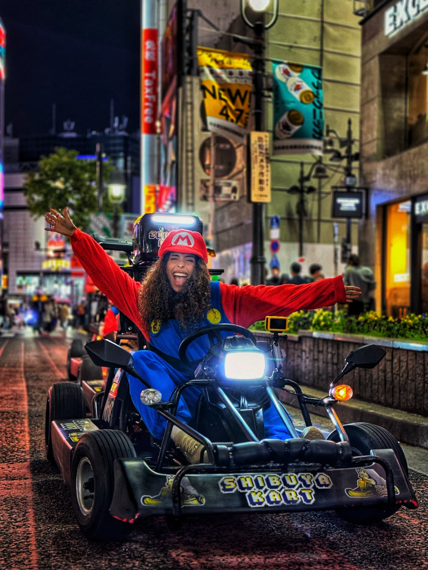Zee souriante dans un kart à Tokyo, la nuit